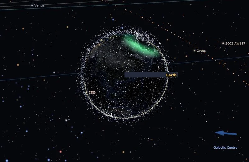Earth with a bright green auroral glow over the northern polar region, inside the shell of satellites.